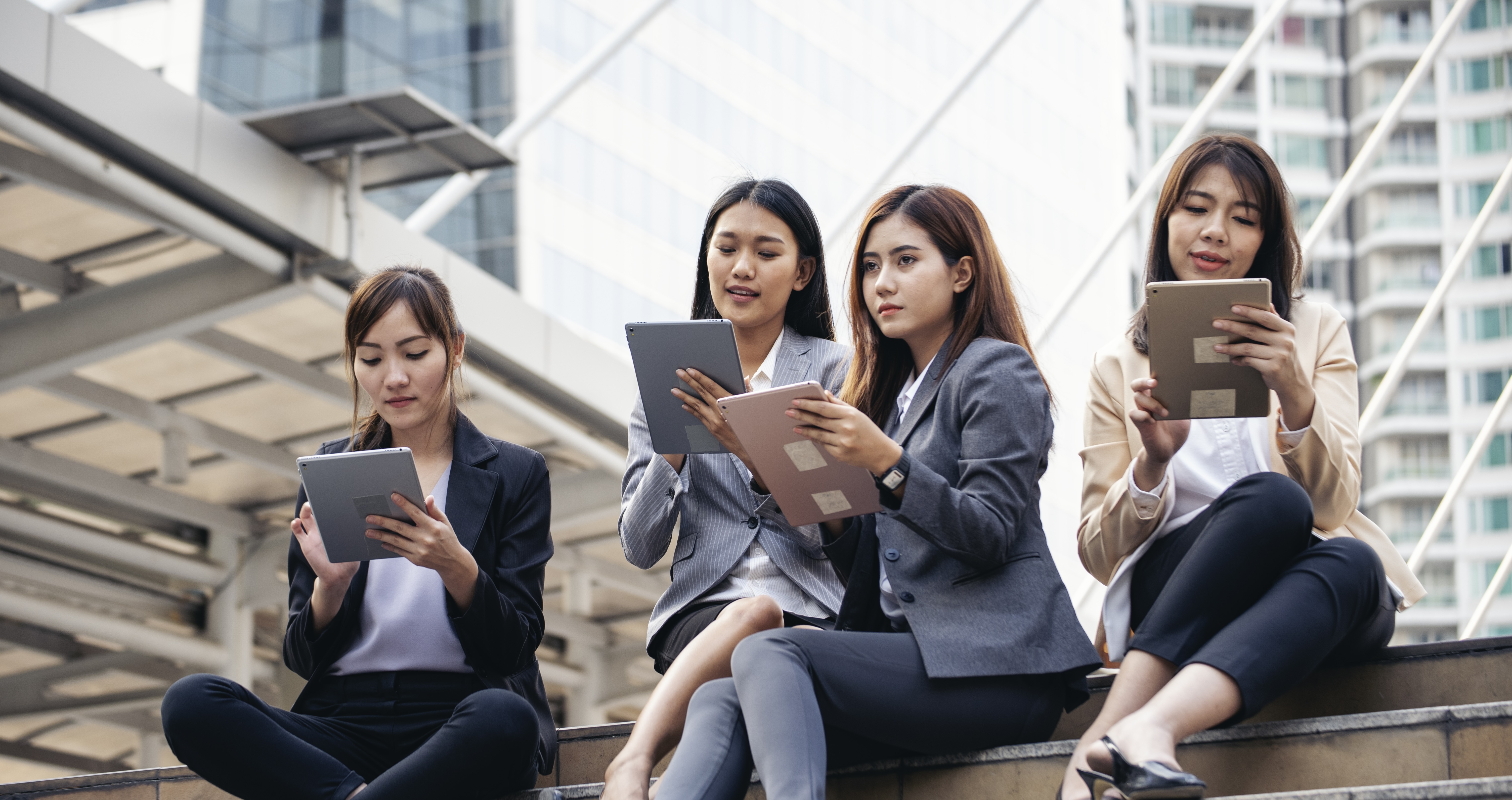 Businesswomen browsing on tablets